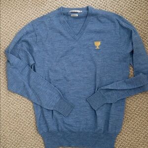 Peter Millar Blue V-Neck Sweater with Presidents Cup logo.